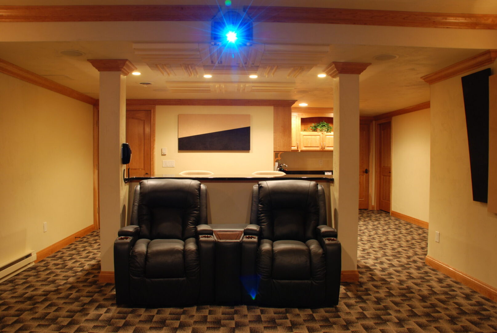 A media projector on above reclining seats in a home theater